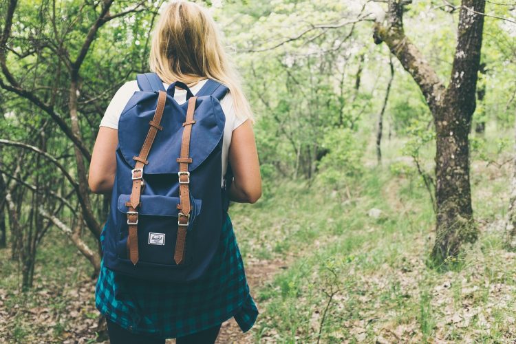photo of woman hiking through the woods with a blue backpack in Nelson County Virginia
